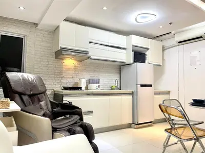 a kitchen with a chair and a refrigerator at Thompson Suites Fort Victoria Tower BGC Loft Type 1BR in Manila