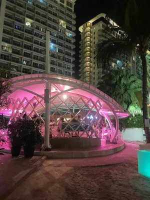 a pink lit up bridge in a city at night at The Solaris Point with Pool View in Manila