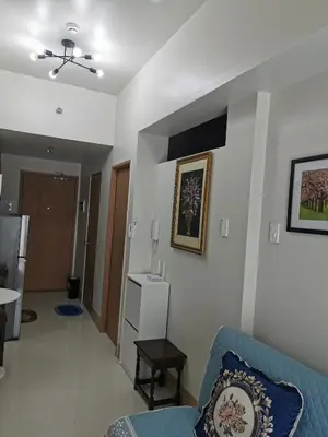 a living room with a blue couch and a table at Mall of Asia condotel in Manila