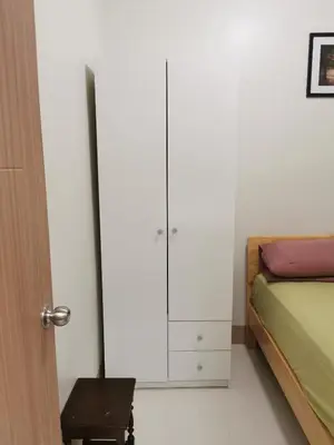 a bedroom with a bed and a white cabinet at Mall of Asia condotel in Manila