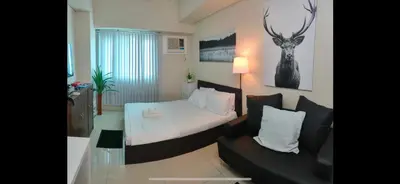 a small bedroom with a bed and a couch at Condo in Makati studio type fast wifi Netflix in Manila