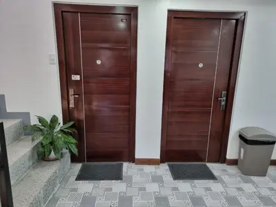 two wooden doors in a hallway with a potted plant at C Mary's Staycation in Tanza Cavite Condo Type with balcony good for 2 person in Tanza
