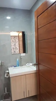 a bathroom with a sink and a wooden door at C Mary's Staycation in Tanza Cavite Condo Type with balcony good for 2 person in Tanza