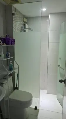 a bathroom with a toilet and a glass shower at ADB AVENUE TOWER in Manila