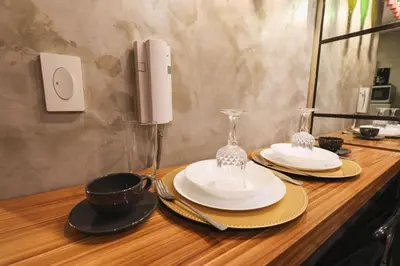 a wooden counter with two plates and glasses on it at Kensal Industrial - Air Residences in Manila