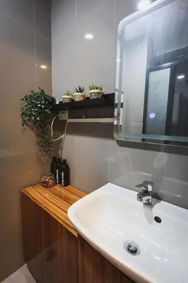 a bathroom with a white sink and a mirror at Kensal Industrial - Air Residences in Manila