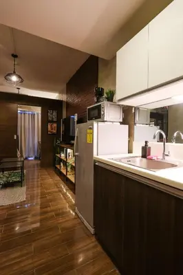 a kitchen with a sink and a refrigerator at Kensal Industrial - Air Residences in Manila