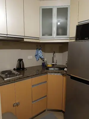 a kitchen with a sink and a refrigerator at Rj Condotel Near Naia Terminal 3 in Manila