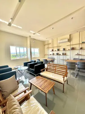 a waiting room with benches and chairs and tables at Fullerton Suites in Puting Kahoy