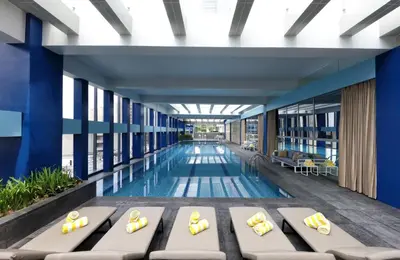 a swimming pool with chaise lounges in a building at Makati Diamond Residences in Manila