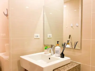 a bathroom with a white sink and a shower at Best BGC Condo Near Uptown Area #oursw30b2 in Manila
