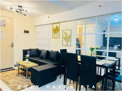 a living room with a couch and a dining room at #46 Urban Deca Homes Ortigas in Manila