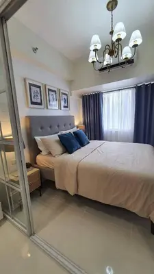 a bedroom with a large bed and a chandelier at Luxury Condo with a view of Manila Bay in Manila