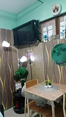 a dining room with a table and a tv at Dencios Transient in Cabuyao