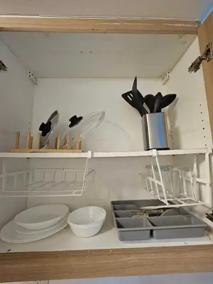 a shelf with plates and utensils in a kitchen at D' Shore Line - Shore Residences MOA PASAY in Manila