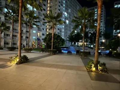 a park at night with palm trees and buildings at D' Shore Line - Shore Residences MOA PASAY in Manila