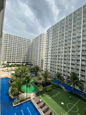 a large building with a tennis court in front of it at D' Shore Line - Shore Residences MOA PASAY in Manila