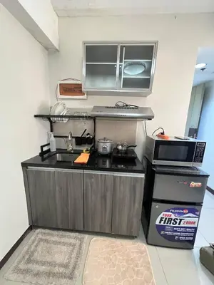 a small kitchen with a stove and a microwave at Solemare Parksuites Condominium in Manila