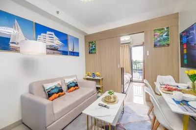 a living room with a couch and a table at 2 Condos, 5 Beds, 2 CR @ Shore2 MOA (3rd&5th Flrs) in Manila