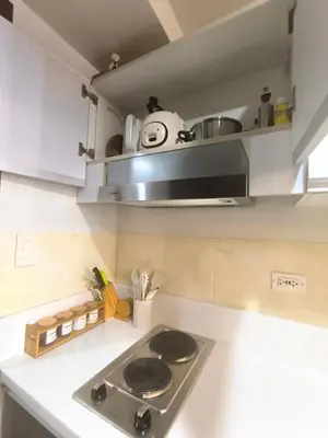 a kitchen with a stove and a counter top at Sun and Moon D'wood air residences makati in Manila