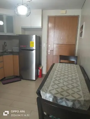 a kitchen with a refrigerator and a table and a table and a room at Two Palm Tree by Nadz in Manila