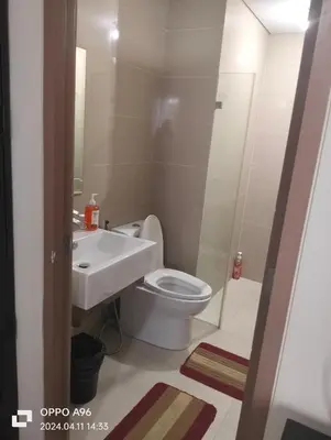 a bathroom with a toilet and a sink at Two Palm Tree by Nadz in Manila