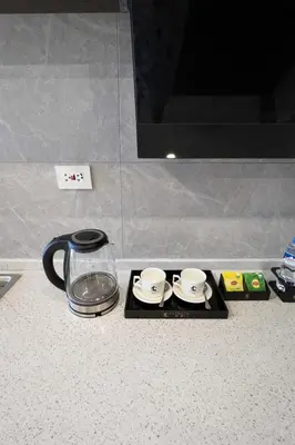 a coffee maker and two cups on a tray on a counter at Studio with Balcony Near Okada Manila and MOA LCONDOTEL in Manila
