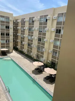 an apartment building with a pool and chairs and a building at Stanford Suites 3, staycation near Nuvali, located in Silang in Bayabasan