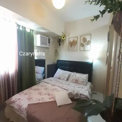 a bedroom with a bed with a pink bedspread at Mezza II Residences Condotel by Czarynah's Crib in Manila