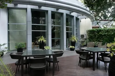 a patio with two tables and chairs in front of a building at Jane in the City! In Avant, BGC in Manila
