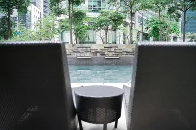 a table and chairs in front of a swimming pool at Solana in Avant BGC parking with fee in Manila