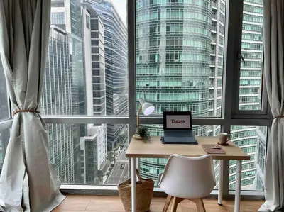 a desk with a laptop on it in front of a window at Tarzan in the City! in Avant BGC parking with fee in Manila