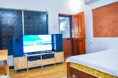 a bedroom with a tv on a stand with a bed at Casa de Madera The Wooden House Staycation Transient and Private Resort in Cabuyao