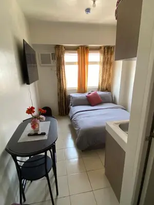 a small room with a bed and a table and a sink at Pierrecondotel in Manila