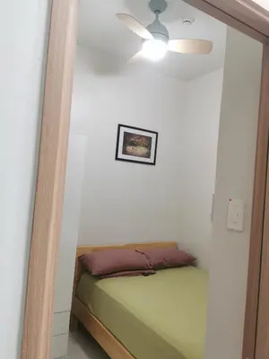 a bedroom with a bed and a ceiling fan at Mall of Asia shore 3 residence in Manila