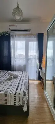 a bedroom with a bed and a large window at Suite 2253 in Manila