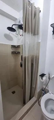 a shower with a shower curtain in a bathroom at Suite 2253 in Manila