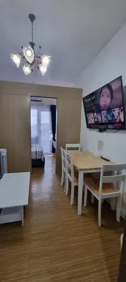 a dining room with a table and chairs with a picture on the wall at Suite 2253 in Manila