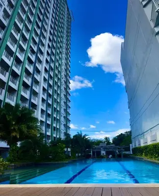 a swimming pool in front of a large building at Sorrel Residences- 2 Bedroom Apartment in Manila
