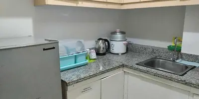 a kitchen counter with a sink and a microwave at Sorrel Residences- 2 Bedroom Apartment in Manila