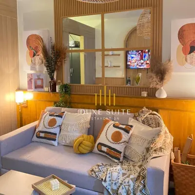 a living room with a blue couch with pillows and a mirror at Cozy Vibes near MOA & NAIA AIRPORT with NETFLIX,MINIVIDEOKE,BOARDGAMES-DUXE3 in Manila