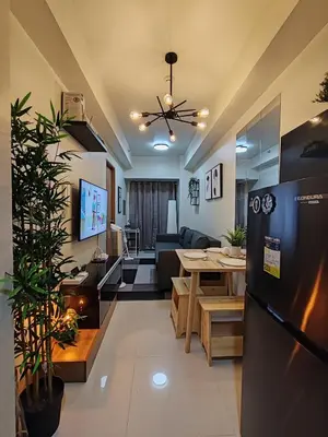 a kitchen and living room with a refrigerator and a table at Haven of Tranquility Suite - SMDC Shore 3 (MOA) in Manila