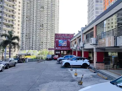 a parking lot with cars parked in front of tall buildings at 1BR Condotel Suite at Sunshine100 City Plaza #SS02 in Manila