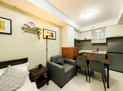 a living room with a couch and a table and a kitchen at 1BR Condotel Suite at Sunshine100 City Plaza #SS02 in Manila