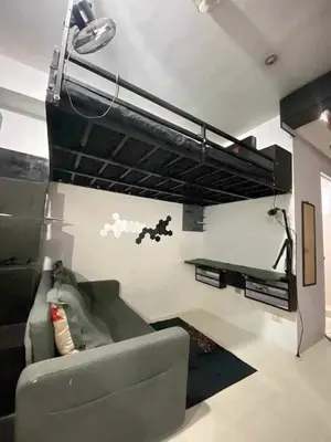 a living room with a couch and a shelf at Khencob's Pad Quezon City in Manila