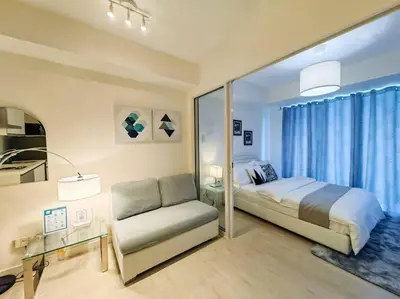 a bedroom with a bed and a couch and a window at 1BR Condotel at Azure Urban Resort Near Airport #AZ03 in Manila