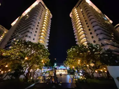 two tall buildings at night with trees between them at 1BR Condotel at Azure Urban Resort Near Airport #AZ01 in Manila