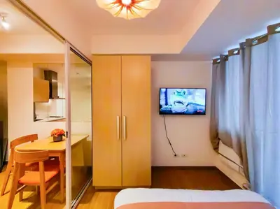 a bedroom with a table and a tv on the wall at 1BR Condotel at Azure Urban Resort Near Airport #AZ02 in Manila