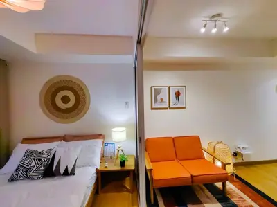 a bedroom with an orange bed and a chair at 1BR Condotel at Azure Urban Resort Near Airport #AZ02 in Manila