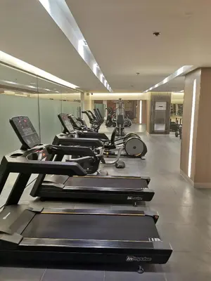 a row of treadmills in a gym with a row at Shore 3 residence mall 'of Asia in Manila